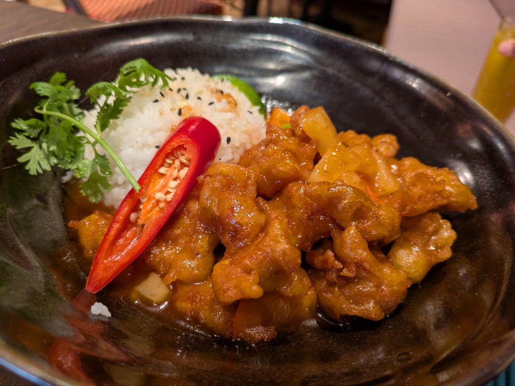 A bowl of rice and sticky chicken pieces