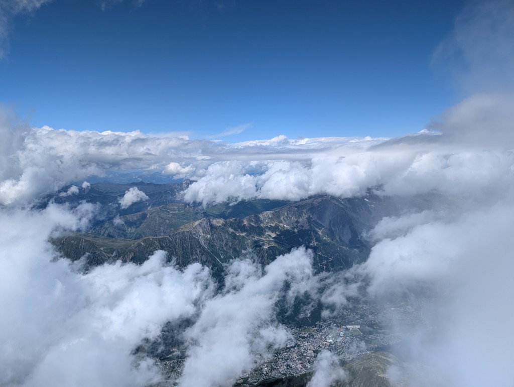 A view down through the clouds at the town below