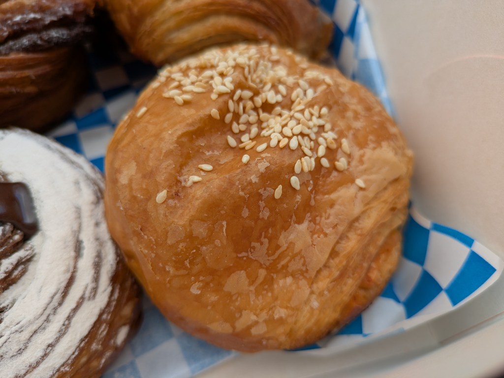 A pesto and cheese bun topped with sesame seeds