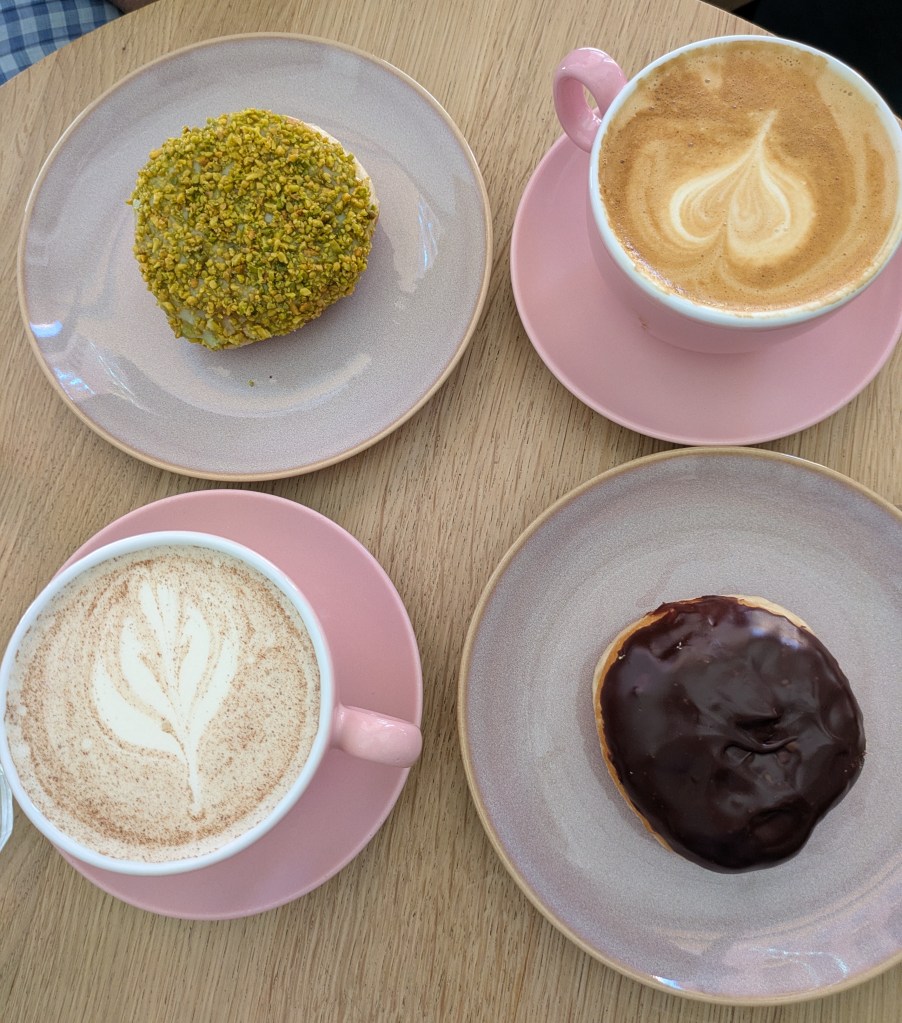 A table with two hot drinks and two doughnuts