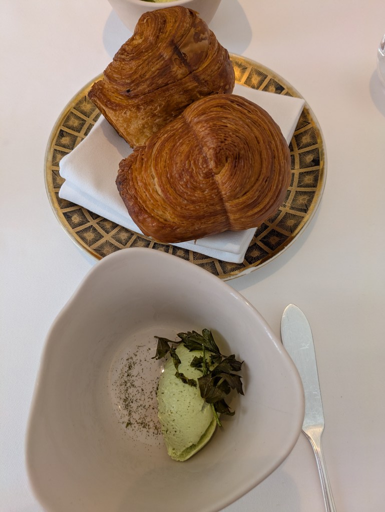 Two well laminated brioches with a dish of whipped green feta 