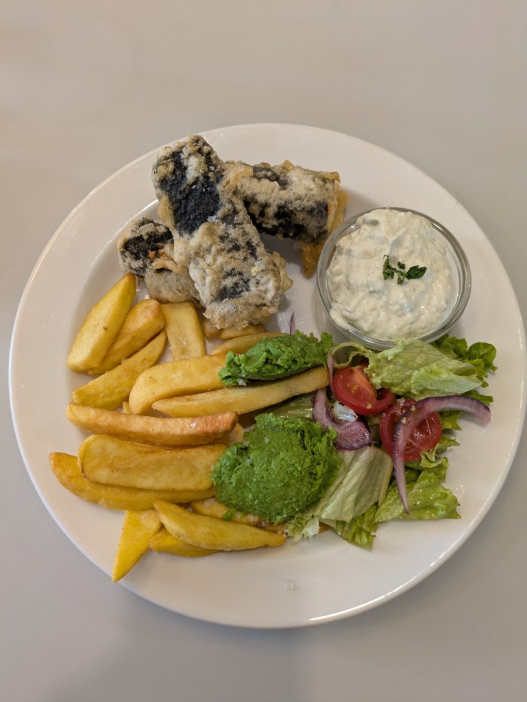 Two blocks of seaweed coated fried tofu, thick cut chips, peas, salad and tartare sauce