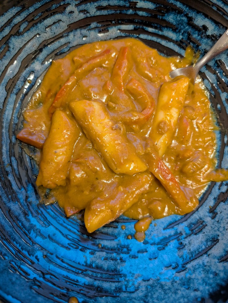 Tteokbokki with strips of vegetables in a thick beige sauce