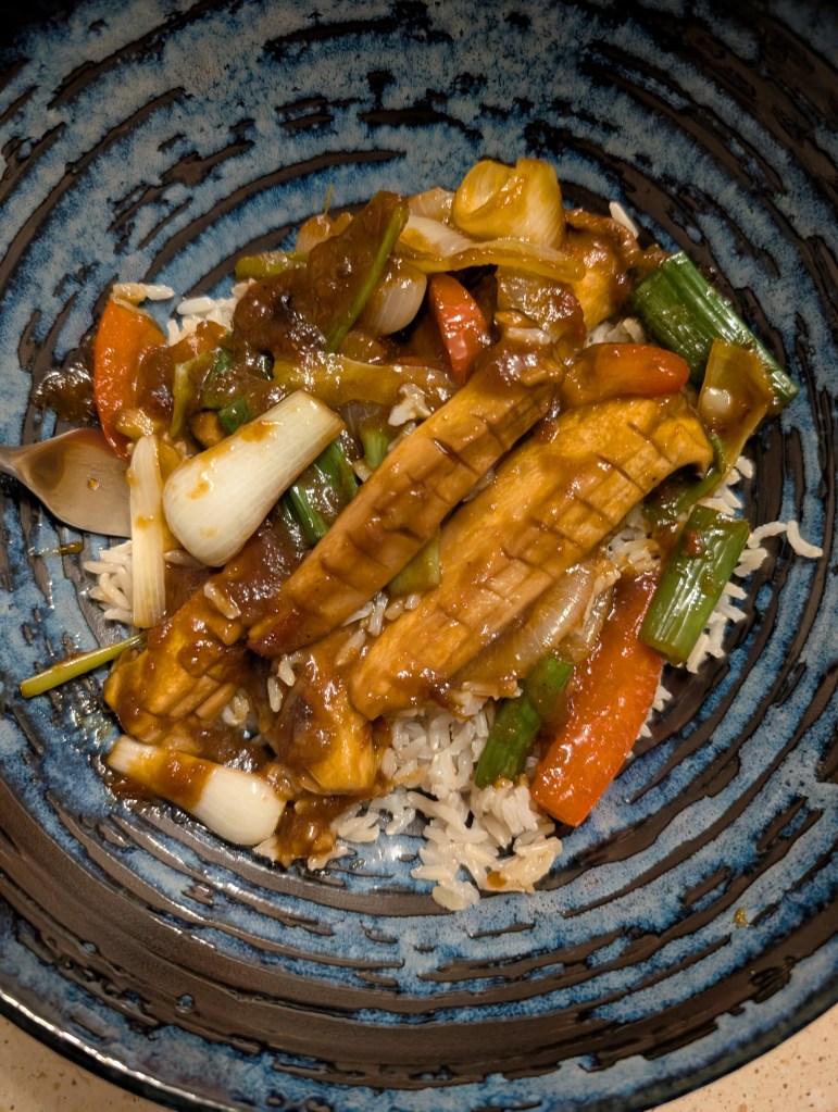 Strips of mushroom and vegetables in a light sauce on top of rice