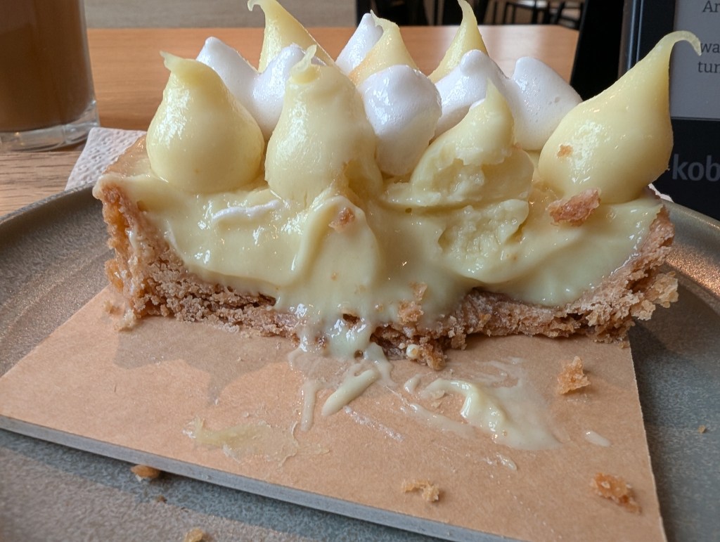 The inside of the lemon meringue tart showing layers of pastry, lemon curd, and piped meringue