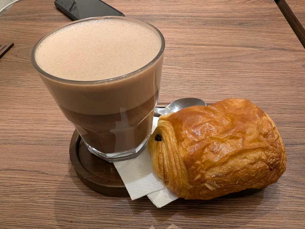 A pain au chocolat and glass of hot chocolate 