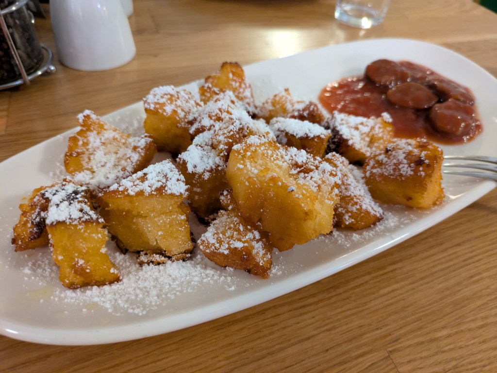 Torn up pieces of pancake with stewed damsons