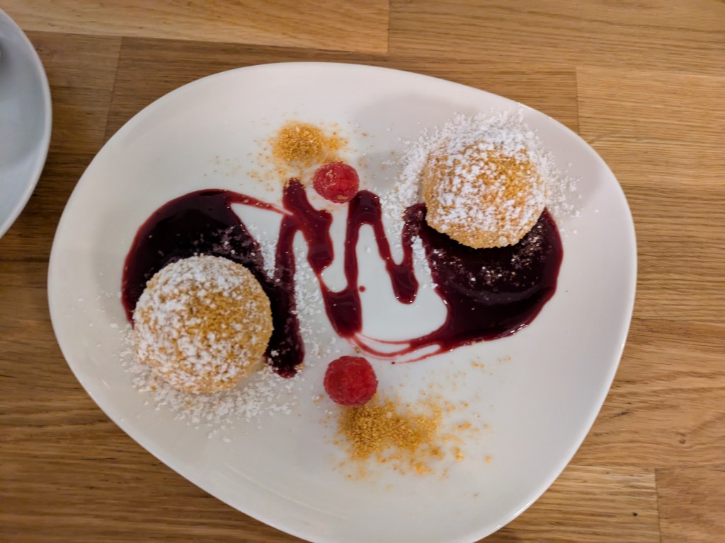 Two dumplings filled with chocolate spread, on a fruit coulis