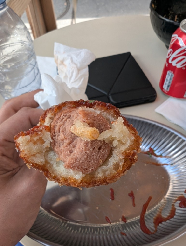 The inside of the corn dog, filled with a sausage 