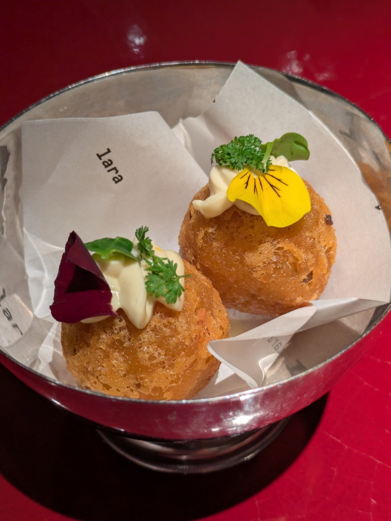 Two crispy croquettes topped with yuzu sauce