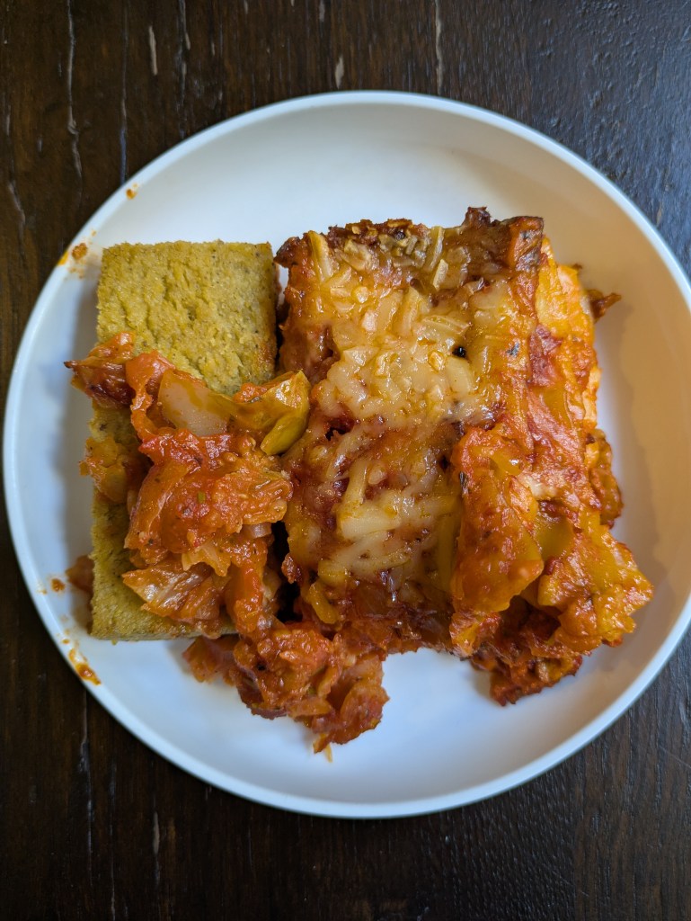 A plate with a slice of polenta cutlet alongside a slice of lasagna