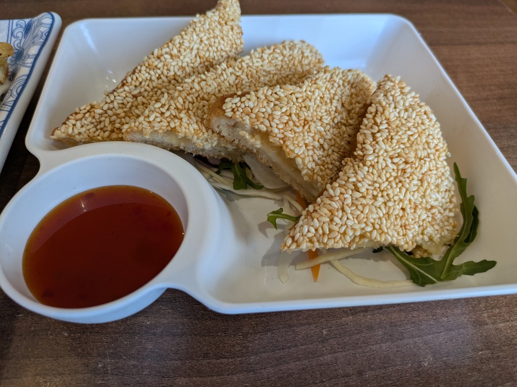 Four slices of sesame toast and a dipping sauce