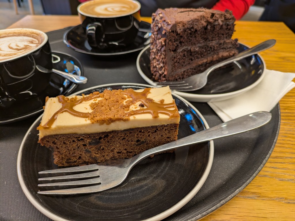 A tray with two cakes and two hot drinks