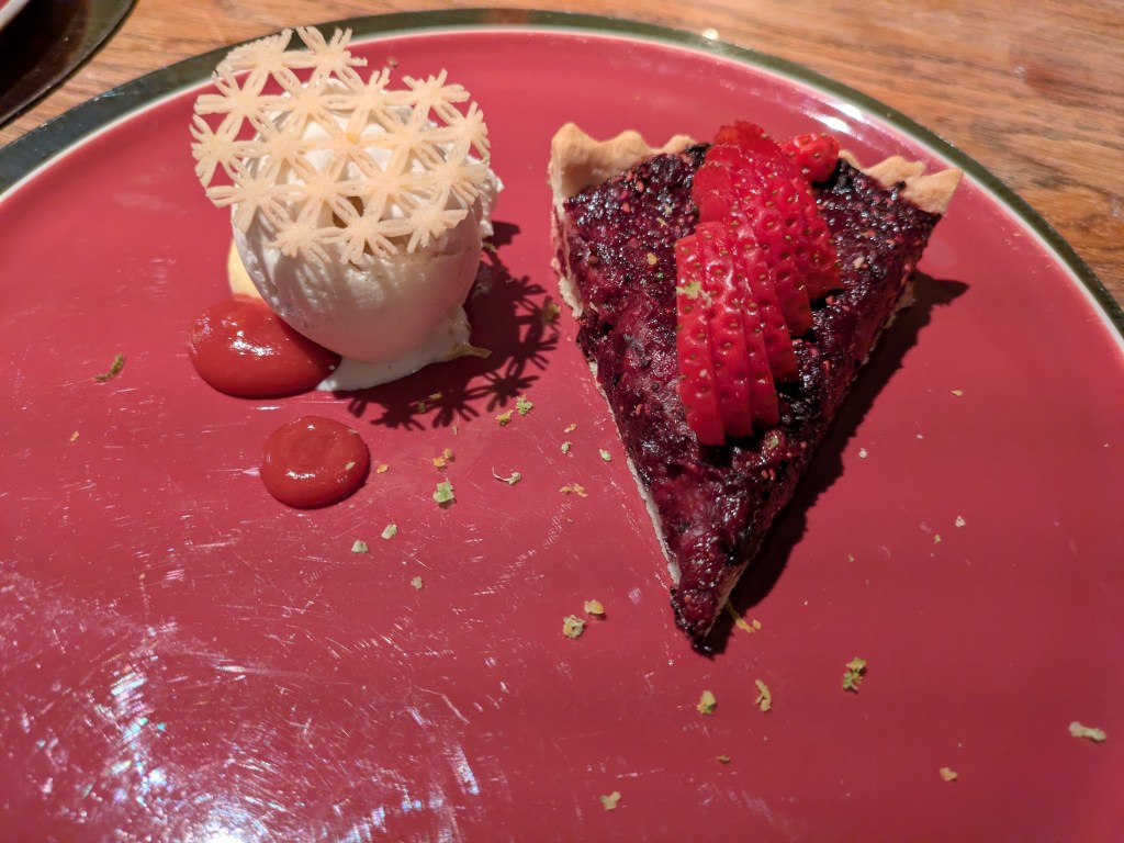 A slice of fruit pie with ice cream