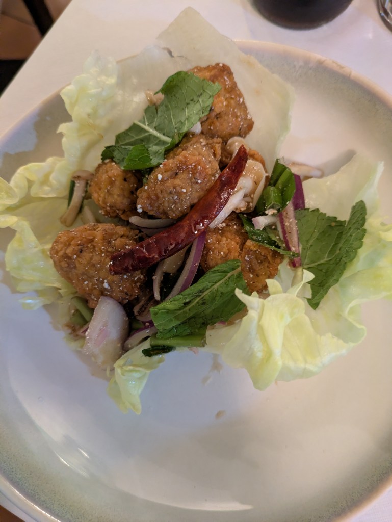 Chunks of chicken with chillies and herbs served in lettuce leaves 