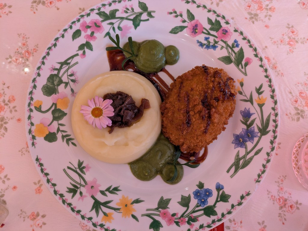 A chicken Kyiv with mashed potato and pea puree