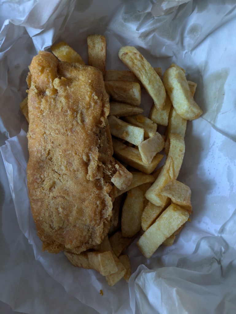A packet of fish and chips, wrapped in paper from the chip shop 