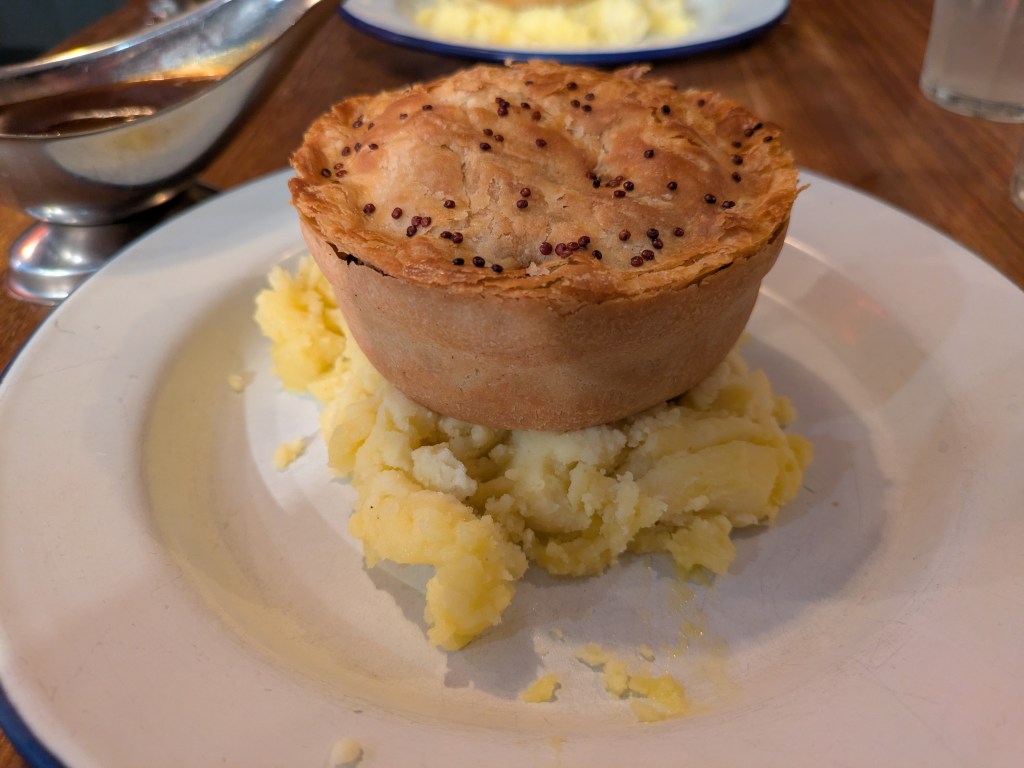 A pie sitting on top of a pile of mashed potato