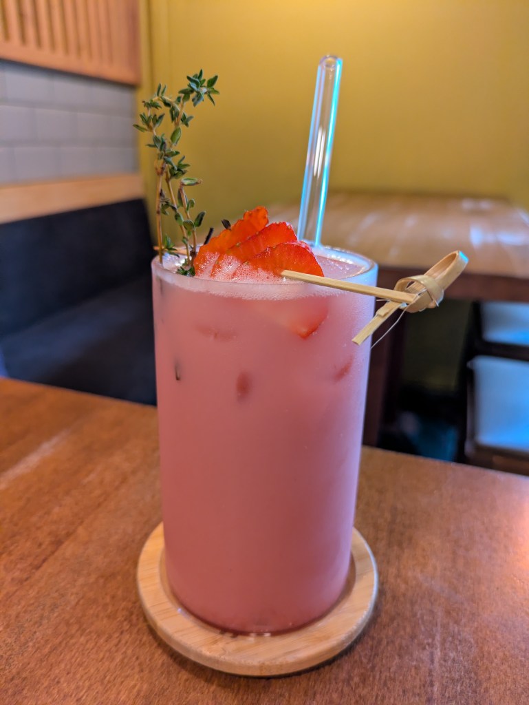 A tall glass filled with a creamy strawberry drink