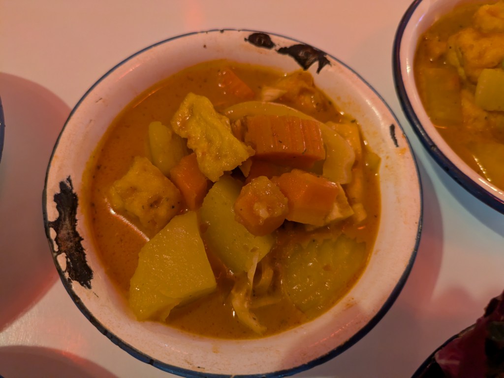 A bowl of curry with large vegetable chunks