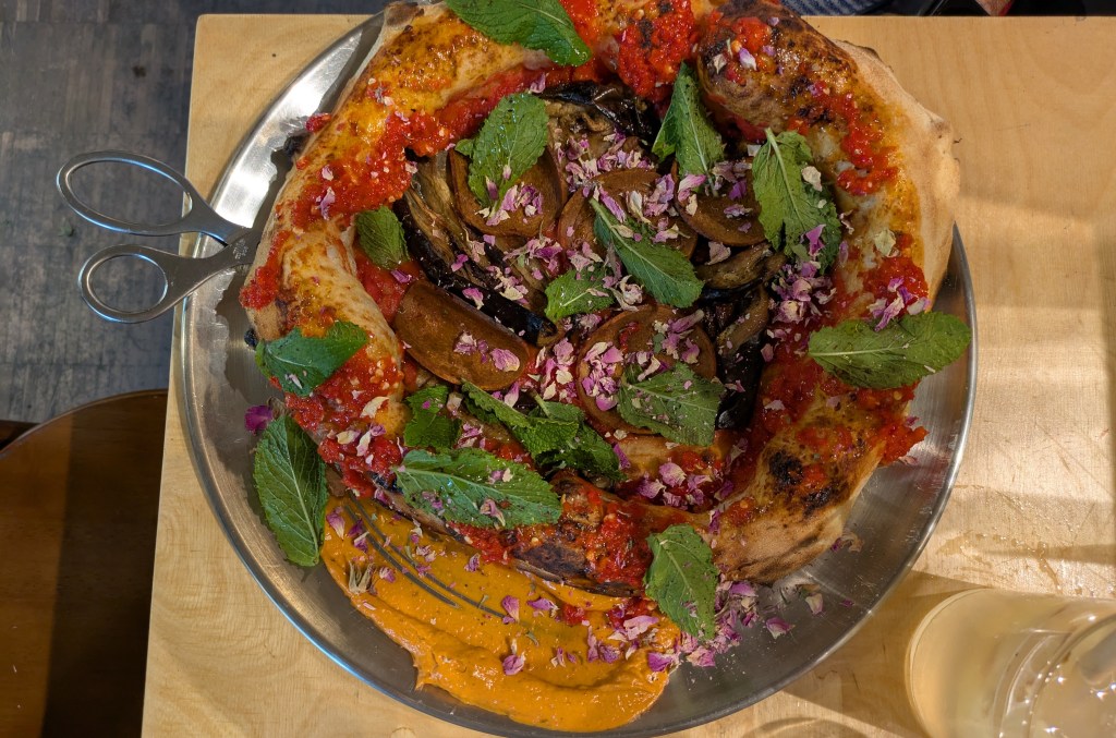 A pizza topped with tomato sauce and aubergine