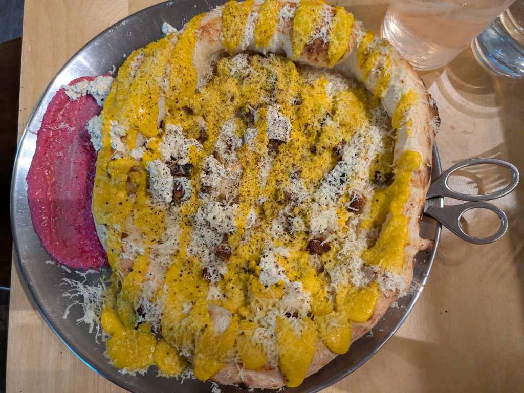 A pizza with lots of cheese and a yellow sauce