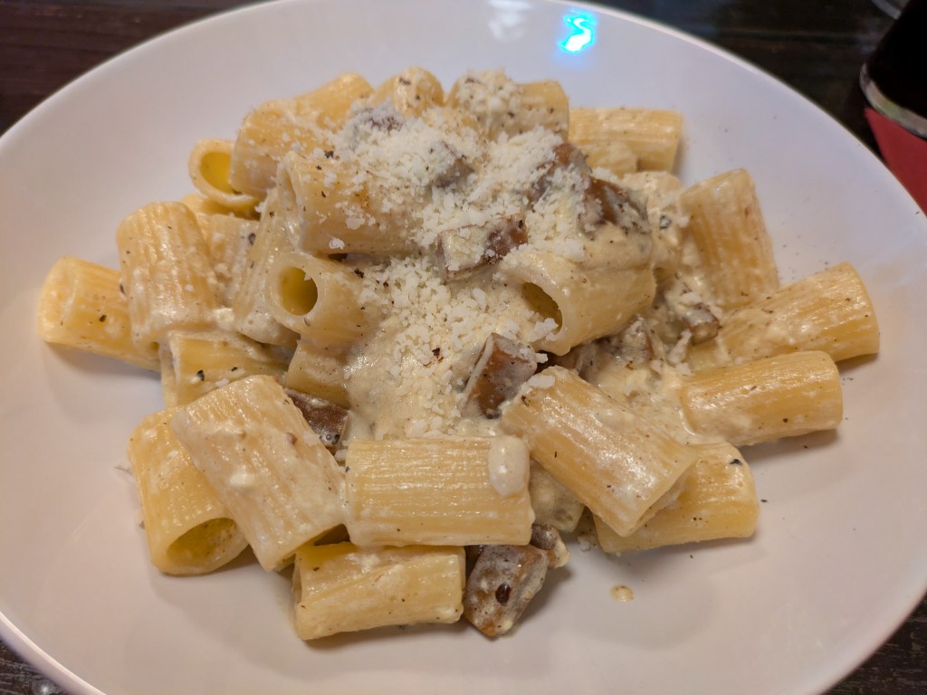 A dish of carbonara with loads of grated cheese on top