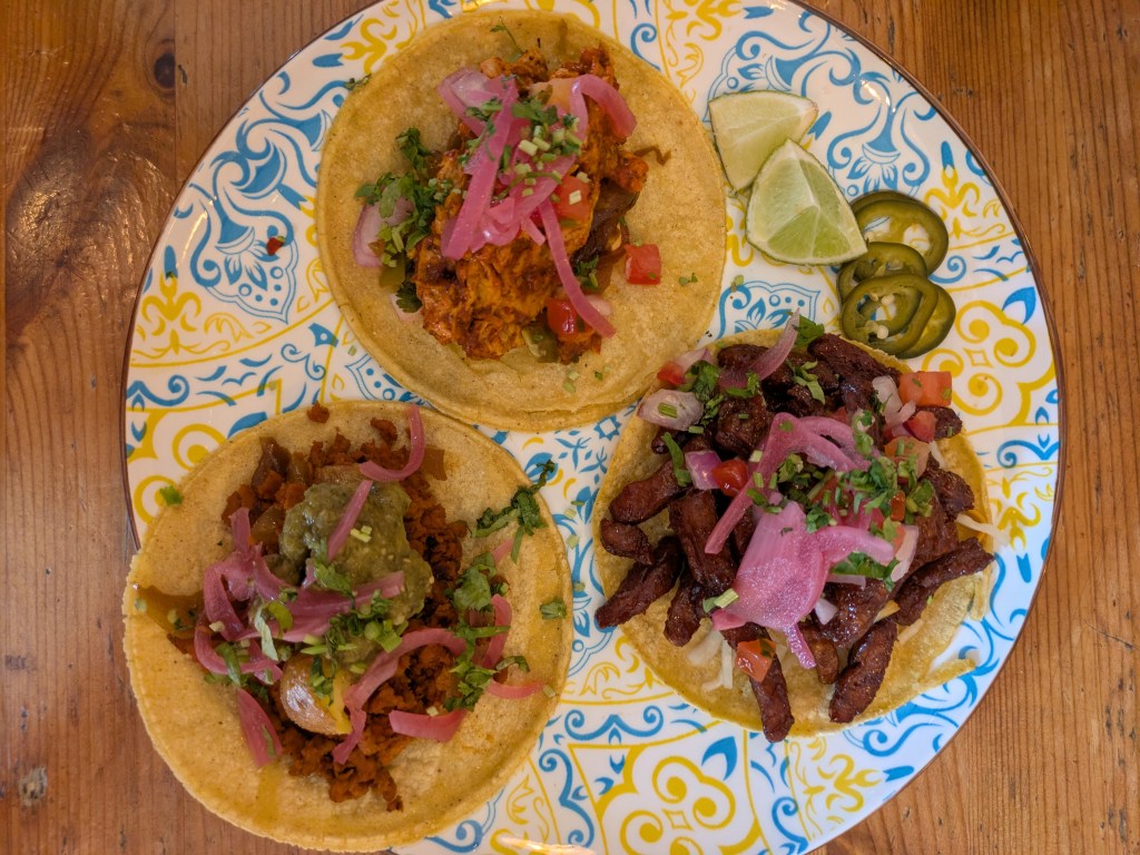 A colourful plate with three different tacos on it