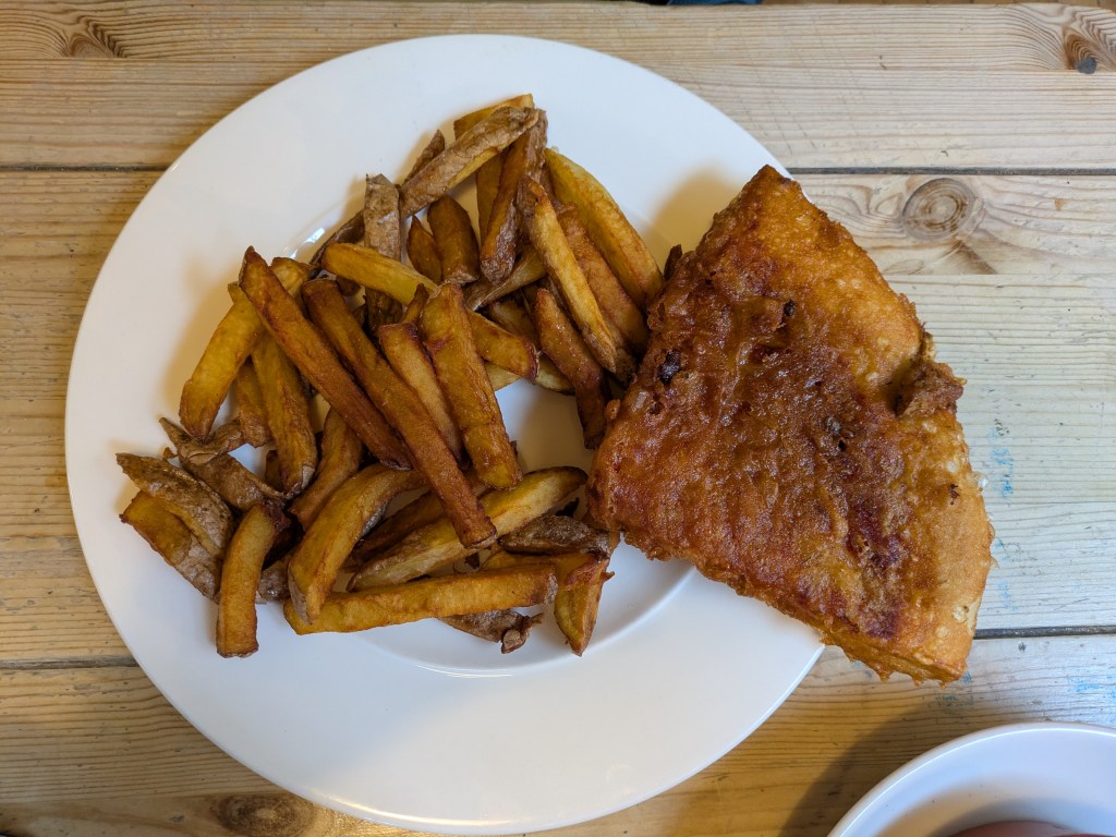 A big portion of chips and a quarter slice of a pizza which has been battered