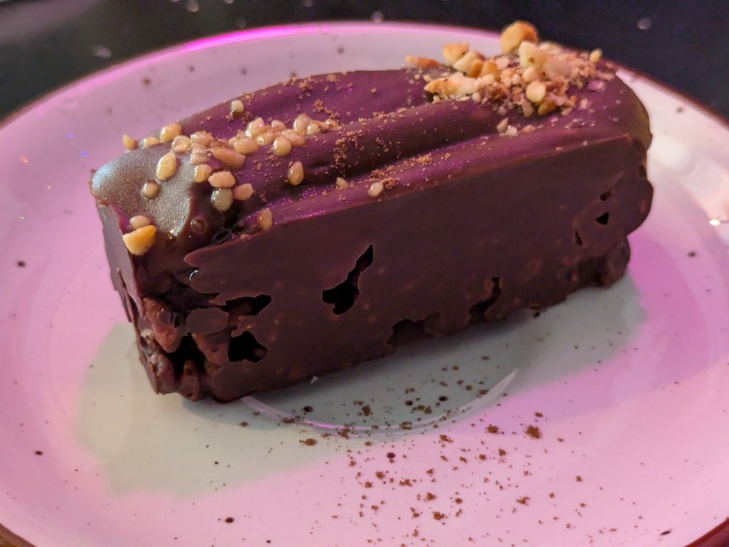 A substantial dessert with a puffed rice base topped with chocolate
