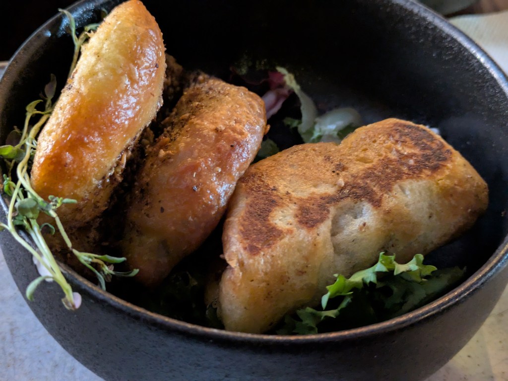 Two thick zaatar breads folded in half in a dish