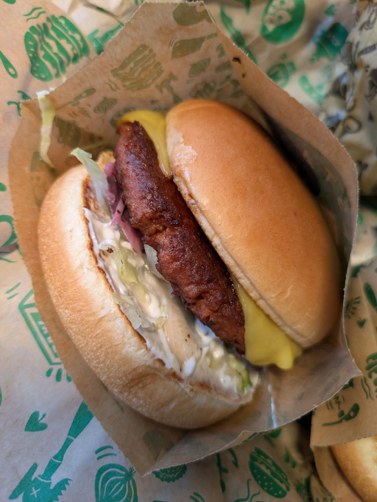 A beef burger with a slice of cheese and mayo