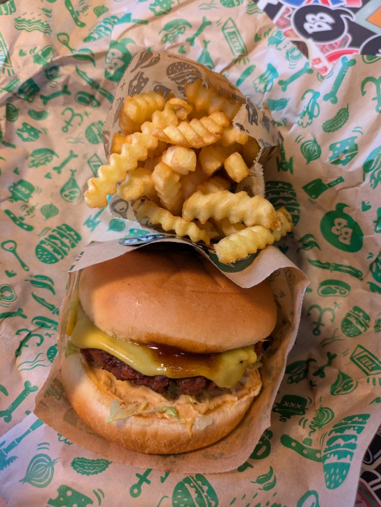 A burger and a bag of chips on a tray